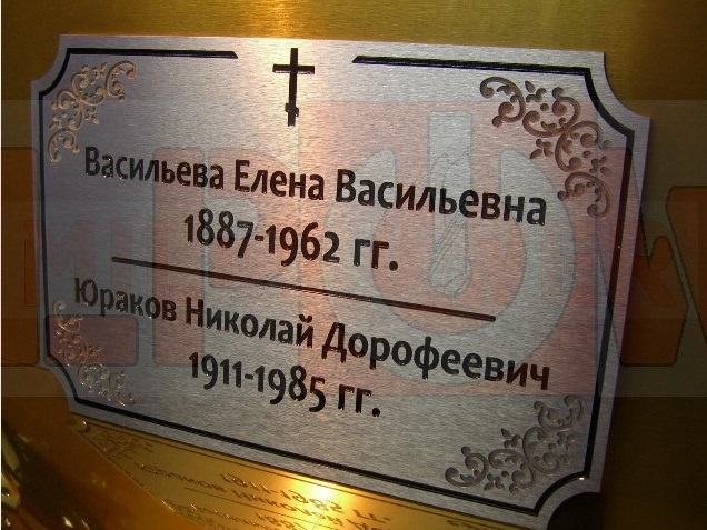 Табличка из нержавейки на памятник нестандартной формы с глубокой гравировкой, покрытием надписей эмалями.
